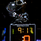 Atlanta Hawks mascot Spirit the Hawk is perched atop a camera on the shot clock.